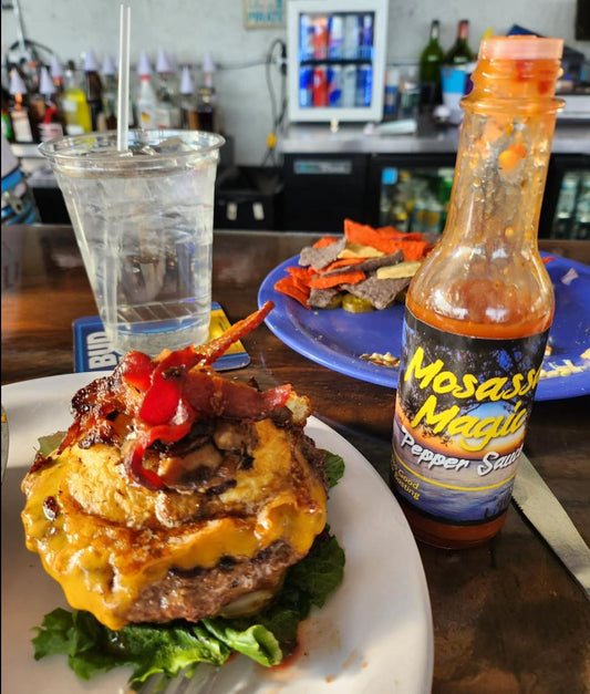Take your burgers to the next level with Mosassa Magic Pepper Sauce. 5 oz bottle shown.